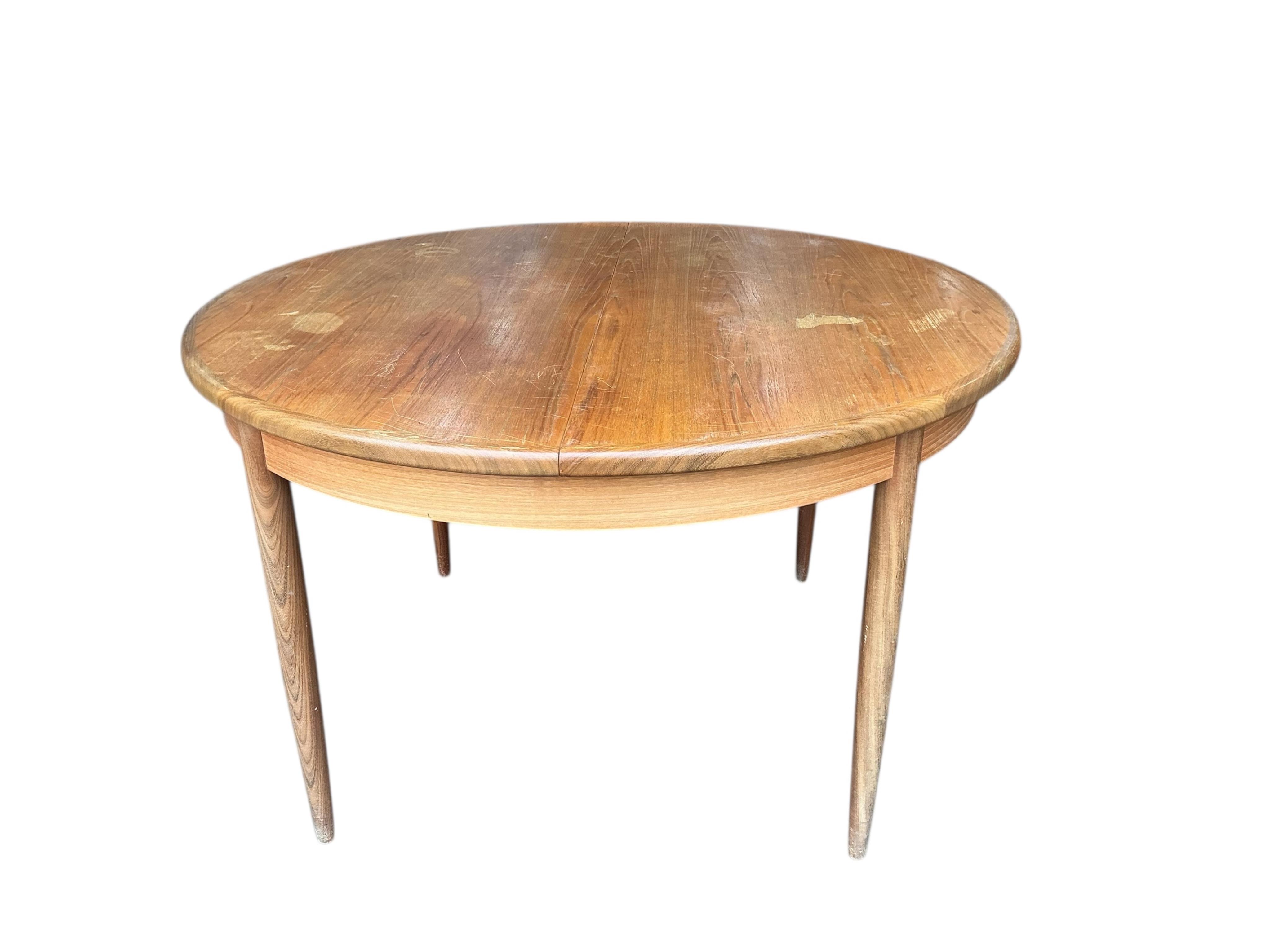 A mid century G Plan Fresco teak extending dining table, diameter 160cm, height 74cm, and four chairs